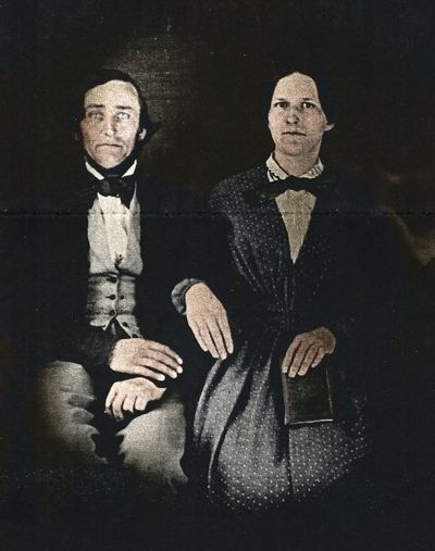 Restored and colorized (AI-assisted); faces are the original photo, colours are a best guess. David Carl Coffman and Emily Thornhill Coffman, c. 1860 — as identified by the uploader.