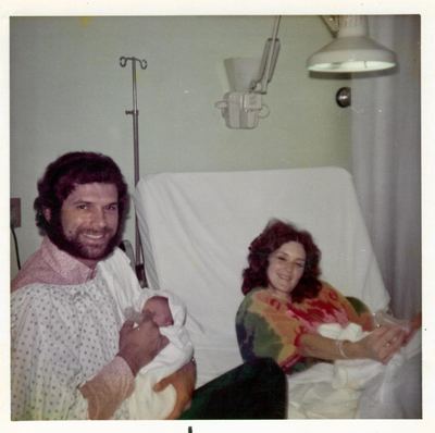 Bill Proeger holding a newborn, with Nancy, 1970s