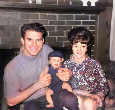 Nancy and Bill Proeger with infant Earl by the fireplace, c. 1967