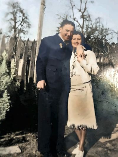 Enhanced (AI-assisted, non-generative): glare reduced, cleaned and upscaled. Mildred A. (Rose) Silva Springer and her second husband William Springer, by a picket fence, 1930s–1940s — from the Patricia Collins collection